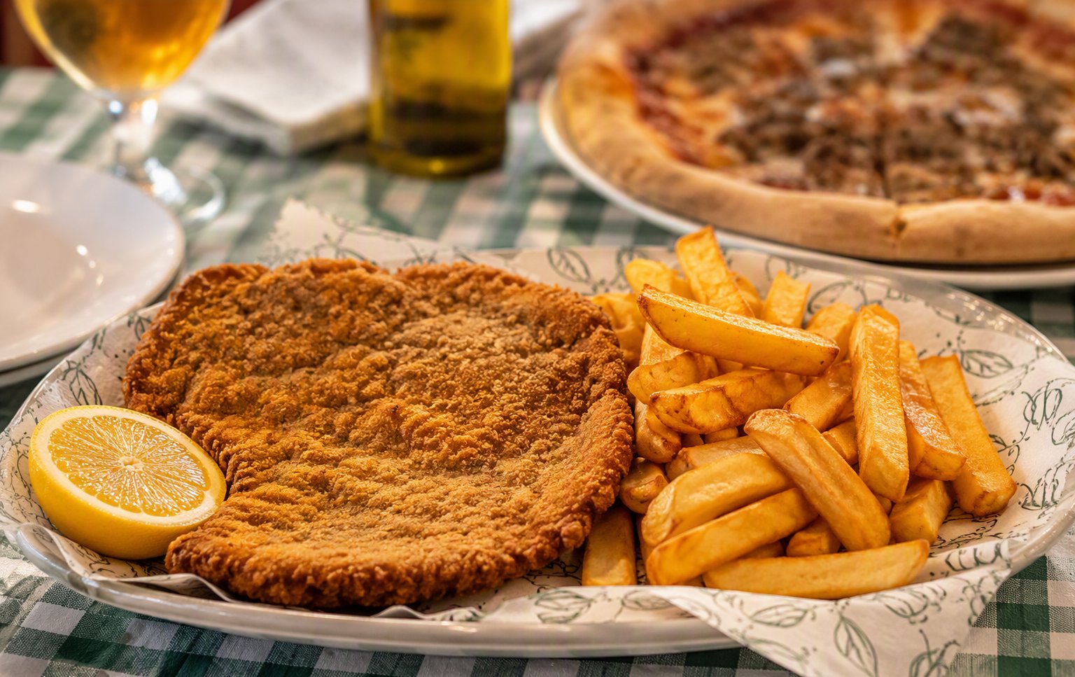 Cotoletta milanesa dorada con patatas fritas y limón en Sapori D'Italia